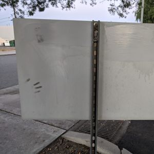 The back of a metal sign at a bank had the graffiti covered with a grey paint
